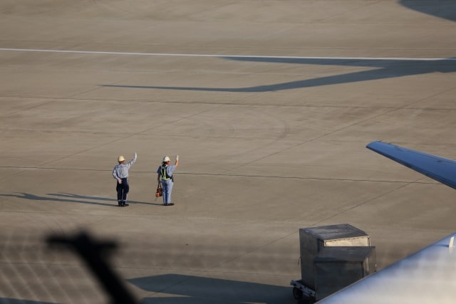 飛行機に手を振る整備士や地上作業員