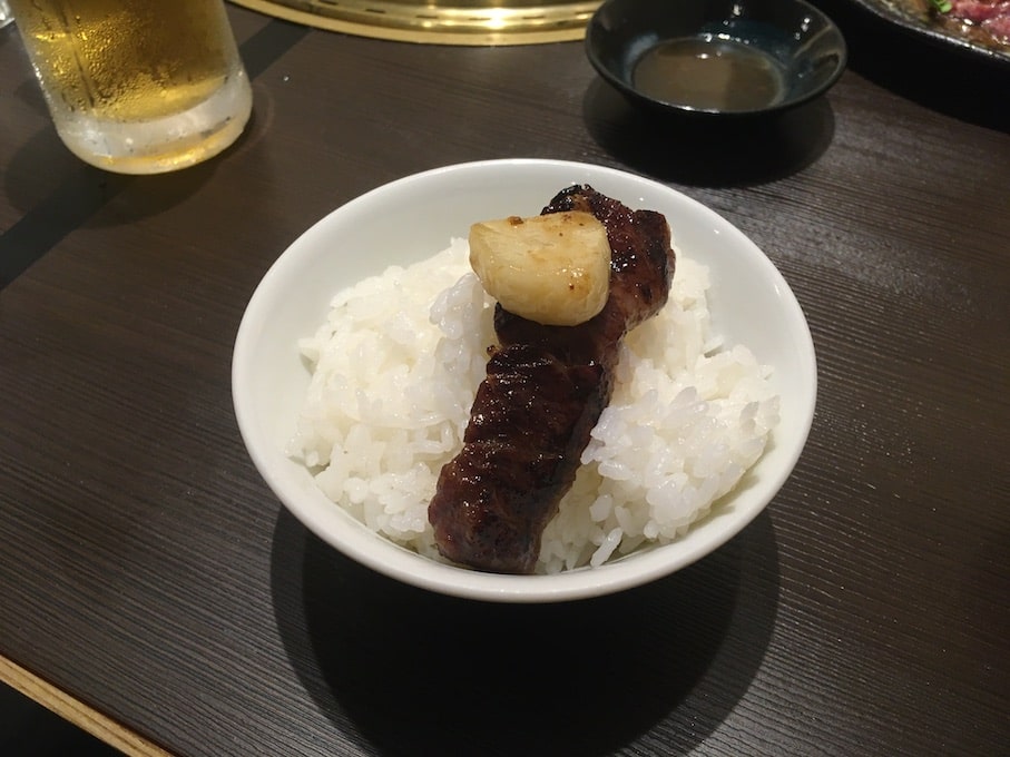 白ご飯にハラミとニンニクを載せて